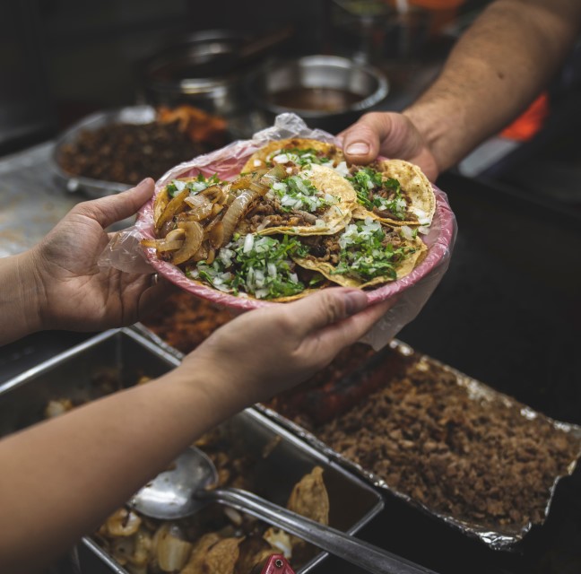 carnitas tacos exchanging hands